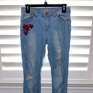 Almost Famous Mid Rise light wash denim jeans with sewed roses